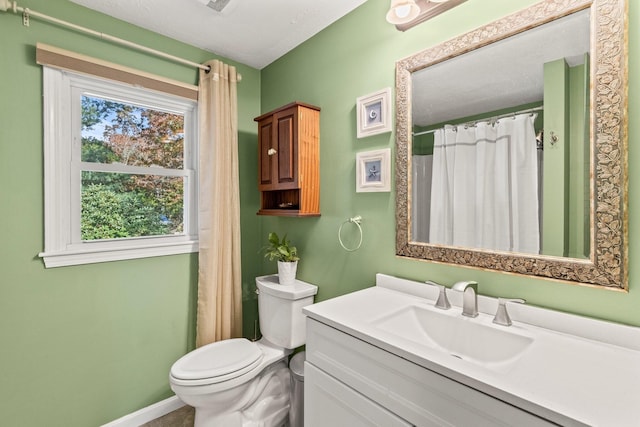 bathroom with toilet, a wealth of natural light, and vanity