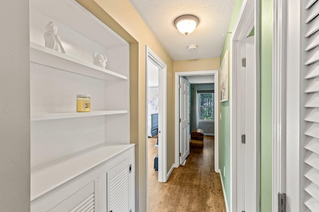 corridor featuring dark wood-type flooring and a textured ceiling