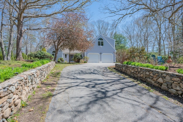 view of side of property featuring a garage and aphalt driveway