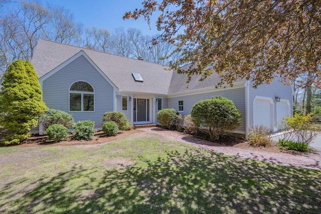 ranch-style home with a shingled roof and a front yard