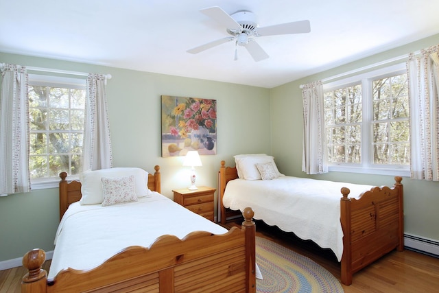 19 Featherbed Ln, Brewster, MA 02631 - bedroom with a baseboard heating unit, light wood-style floors, a ceiling fan, and baseboards