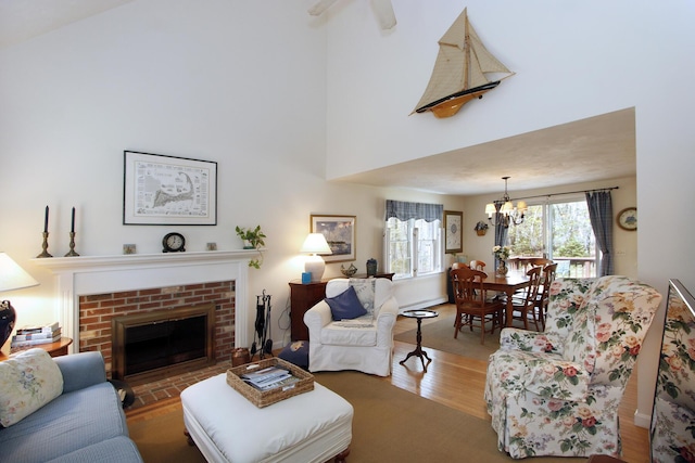 19 Featherbed Ln, Brewster, MA 02631 - living area with a chandelier, wood finished floors, a fireplace, and a high ceiling