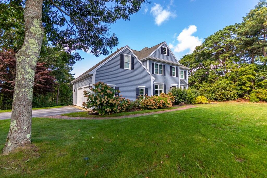 24 Longshank Cir, Hatchville, MA 02536 - view of front of property with driveway, a front lawn, and an attached garage