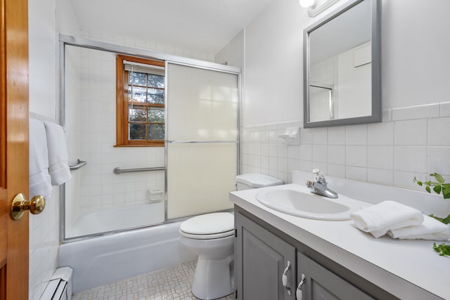 7 George St, Barnstable, MA 02630 - bathroom featuring a baseboard heating unit, vanity, tile walls, toilet, and enclosed tub / shower combo