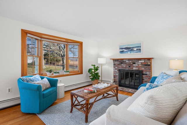 7 George St, Barnstable, MA 02630 - living room with wood finished floors, a baseboard radiator, and a brick fireplace