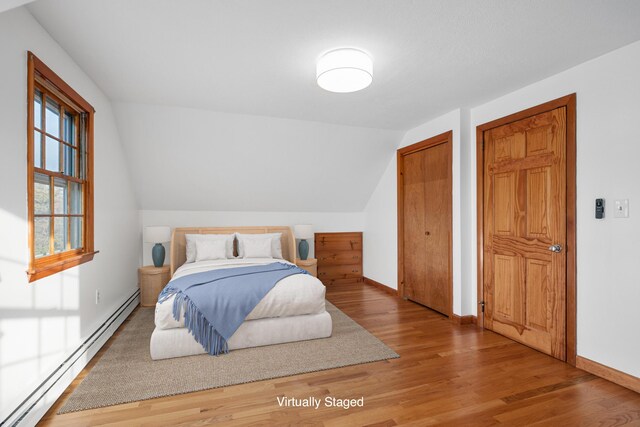 7 George St, Barnstable, MA 02630 - bedroom with a baseboard heating unit, wood finished floors, multiple closets, and vaulted ceiling