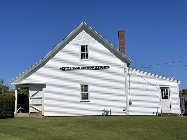 34 Oak St, Harwich, MA 02645 - view of side of property with a lawn and a chimney