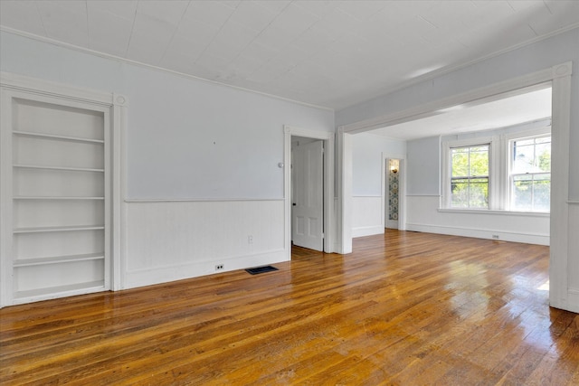 34 Oak St, Harwich, MA 02645 - spare room with built in features, wood-type flooring, a wainscoted wall, and ornamental molding