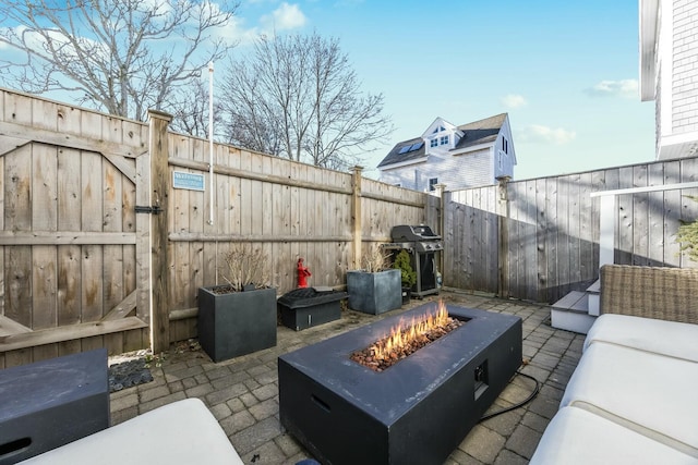 view of patio with area for grilling and an outdoor living space with a fire pit