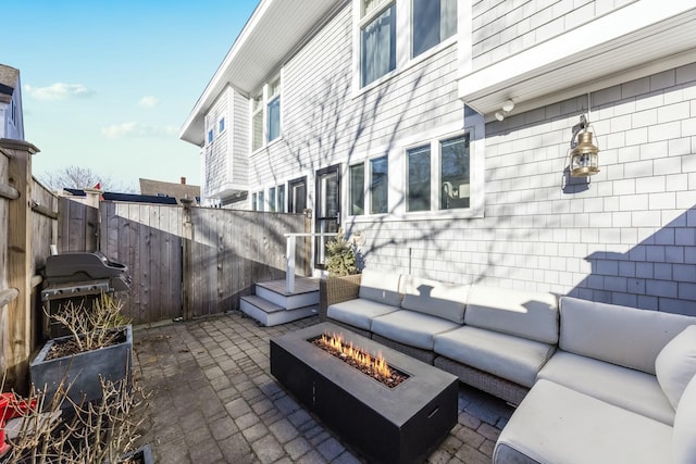 view of patio with a grill and an outdoor living space with a fire pit