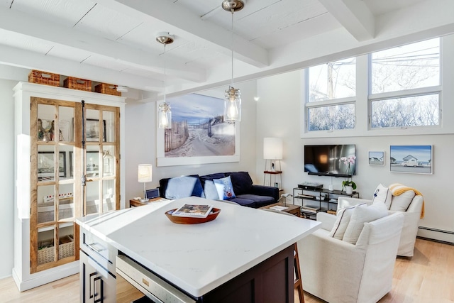 interior space with beamed ceiling, light hardwood / wood-style floors, and a baseboard heating unit