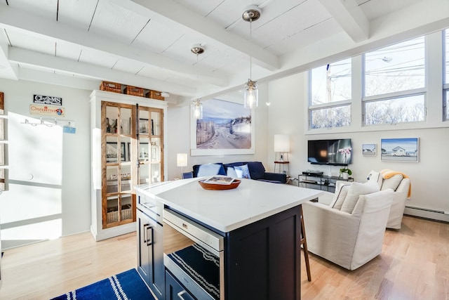 kitchen featuring hanging light fixtures, beam ceiling, light hardwood / wood-style floors, and a center island