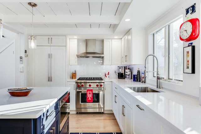 kitchen featuring white cabinetry, sink, luxury range, beam ceiling, and wall chimney exhaust hood