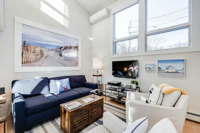 living room featuring a baseboard radiator, a wall mounted air conditioner, light wood-type flooring, and a high ceiling