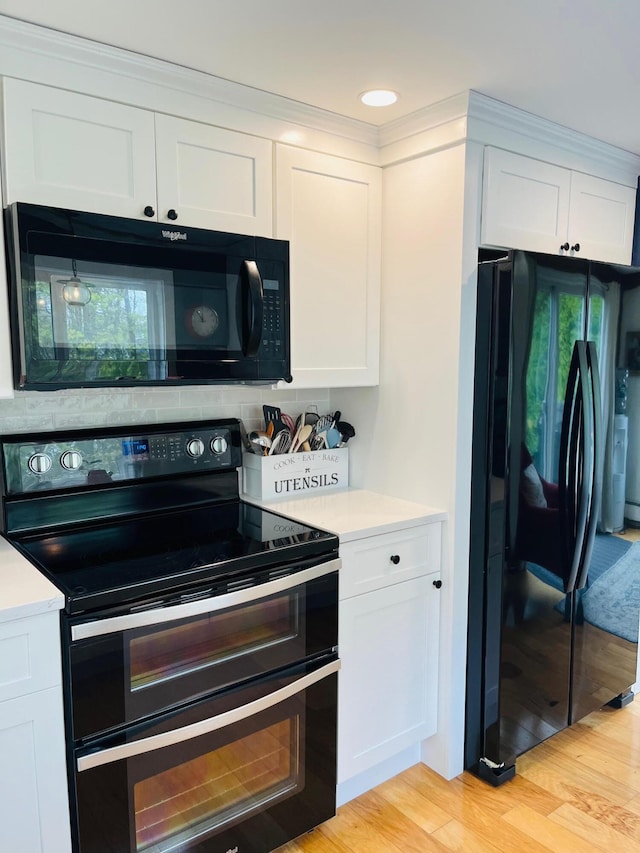 29 Chipman Rd, Sandwich, MA 02563 - kitchen featuring white cabinetry, black appliances, light countertops, and light wood finished floors