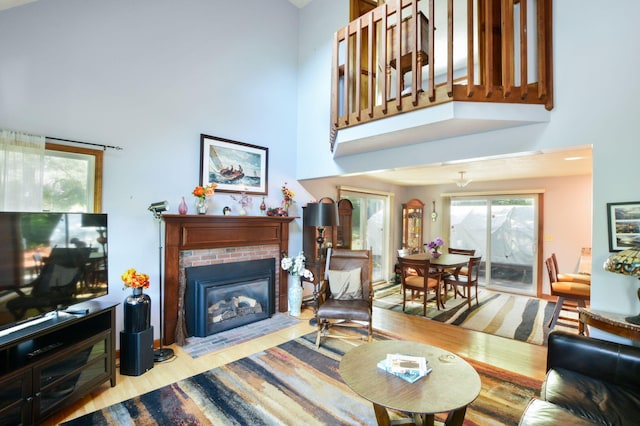 59 Whitecaps Dr, East Falmouth, MA 02536 - living room featuring a towering ceiling, wood finished floors, and a brick fireplace