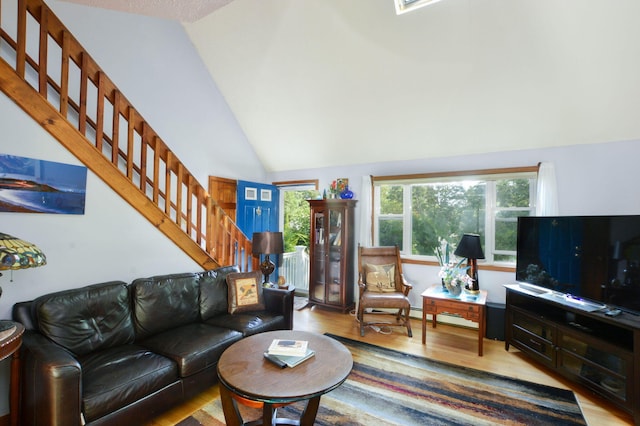 59 Whitecaps Dr, East Falmouth, MA 02536 - living area with wood finished floors, stairway, vaulted ceiling, and a baseboard heating unit