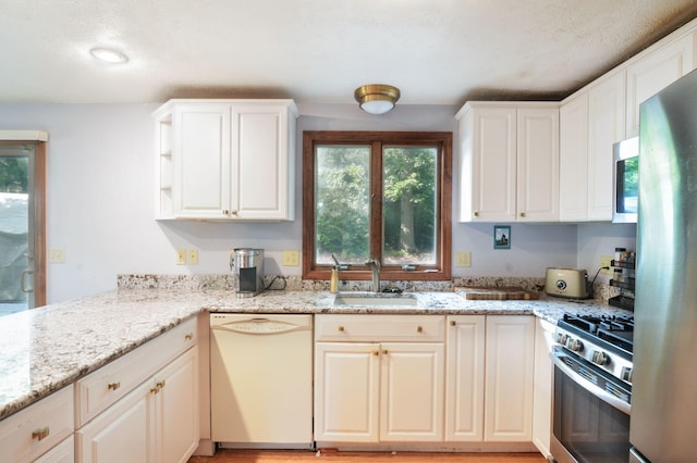 59 Whitecaps Dr, East Falmouth, MA 02536 - kitchen with stainless steel appliances, healthy amount of natural light, light stone countertops, and a textured ceiling