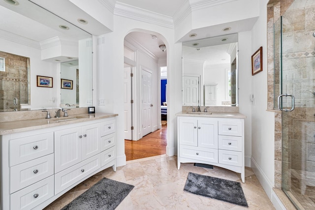 bathroom featuring crown molding, a sink, and a shower stall