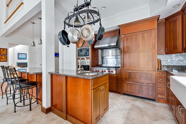 kitchen with black microwave, stainless steel oven, brown cabinets, tasteful backsplash, and dark stone countertops