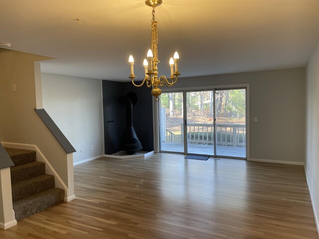 unfurnished room with a wood stove and hardwood / wood-style floors