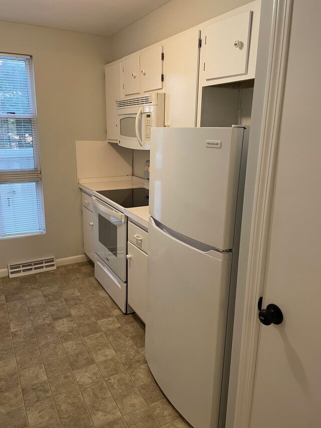 kitchen featuring white cabinetry and white appliances