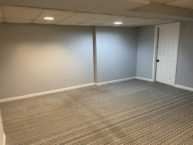 basement featuring a drop ceiling and carpet