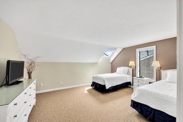 carpeted bedroom featuring baseboards and vaulted ceiling with skylight