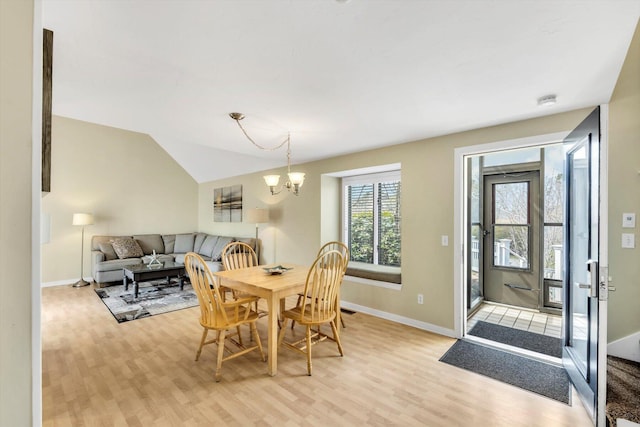 dining room with baseboards, a notable chandelier, and light wood-style floors