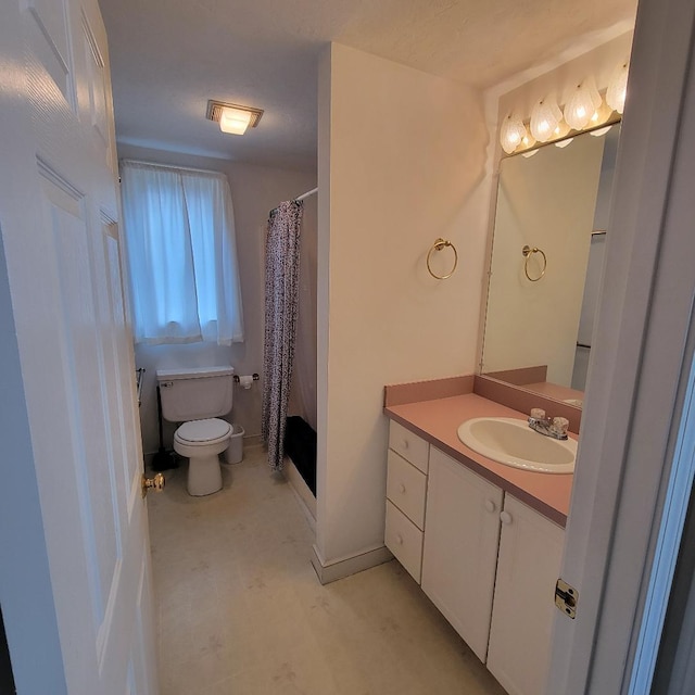 bathroom featuring toilet, walk in shower, and vanity