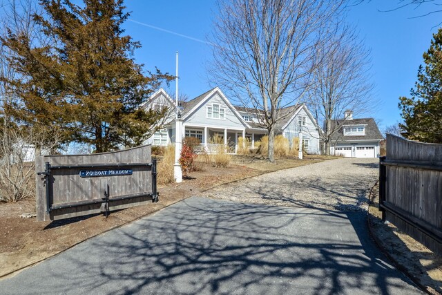 view of front facade featuring a garage, a porch, and aphalt driveway