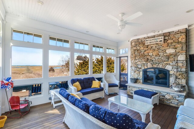 living room with a ceiling fan, a fireplace, and wood-type flooring