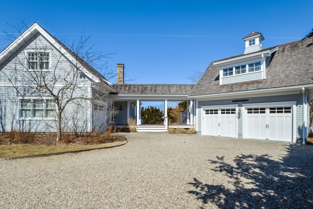 view of front of house with driveway, a porch, and a garage