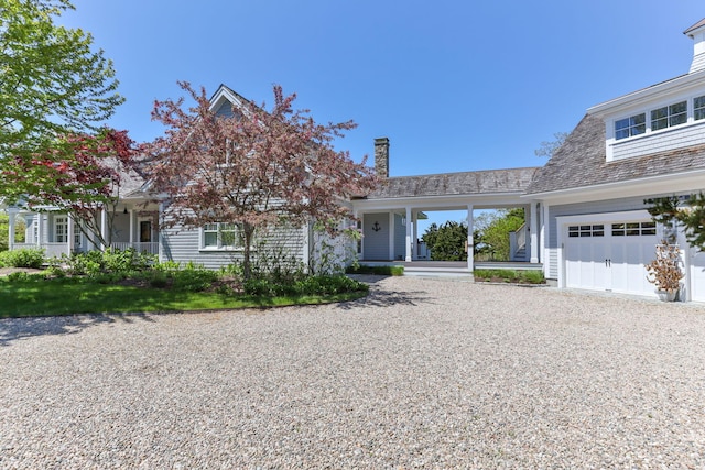 20 Boat Meadow Way, Eastham, MA 02642 - view of front of house with a chimney, covered porch, a garage, and gravel driveway