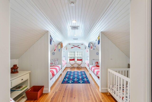 bedroom featuring lofted ceiling, hardwood / wood-style flooring, wooden ceiling, and visible vents