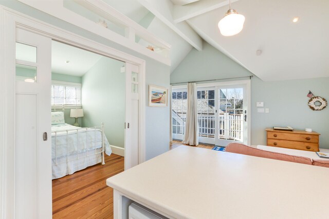 bedroom with light wood-type flooring, lofted ceiling with beams, baseboards, and access to exterior