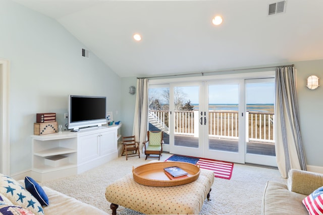 living area featuring vaulted ceiling, visible vents, carpet floors, and french doors