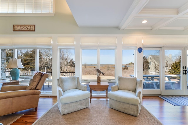 sunroom featuring beamed ceiling, wood finished floors, coffered ceiling, and a healthy amount of sunlight