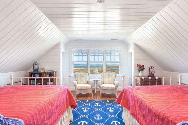 bedroom featuring wooden walls and vaulted ceiling