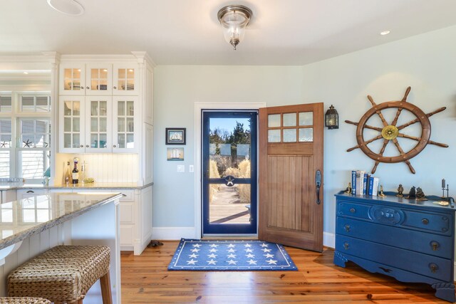 interior space featuring light wood-type flooring and baseboards