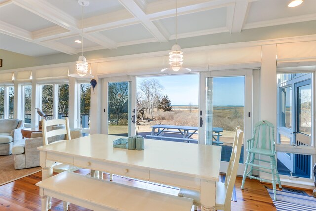 dining space with wood finished floors, beam ceiling, and coffered ceiling