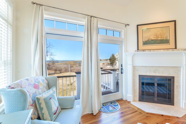 sitting room featuring a glass covered fireplace and wood finished floors