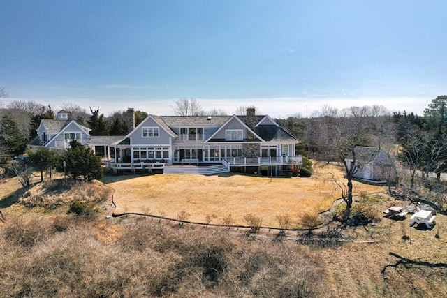 rear view of property featuring a lawn and a deck