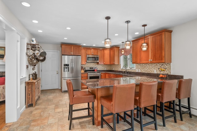 29 Water View Cir, Centerville, MA 02632 - kitchen featuring appliances with stainless steel finishes, a peninsula, brown cabinetry, stone finish floors, and decorative backsplash