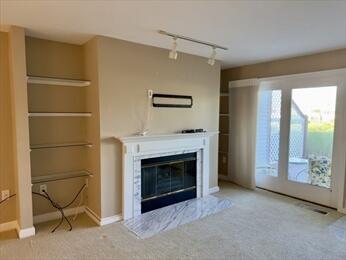 6 Sea Cliff Dr E Unit 6, Cedarville, MA 02360 - unfurnished living room with carpet, rail lighting, and a fireplace with flush hearth
