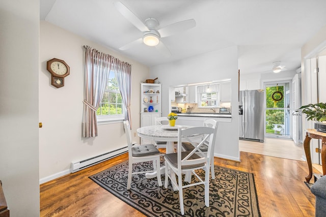 441 Buck Island Rd Unit B1, West Yarmouth, MA 02673 - dining room featuring a baseboard heating unit, light wood-style floors, and a ceiling fan