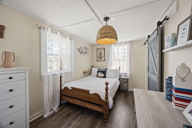bedroom with baseboards, a barn door, and dark wood-style flooring