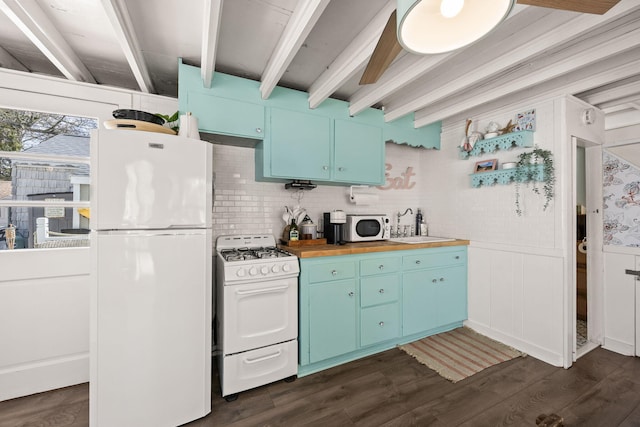 kitchen featuring blue cabinetry, beam ceiling, a sink, white appliances, and butcher block countertops