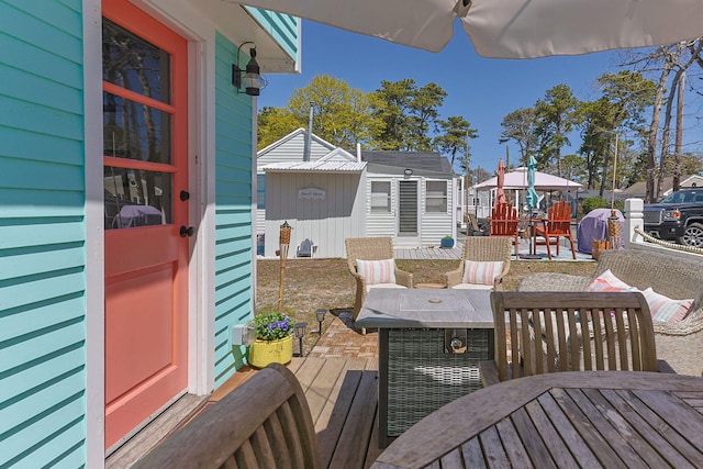 deck with an outdoor structure and outdoor dining area