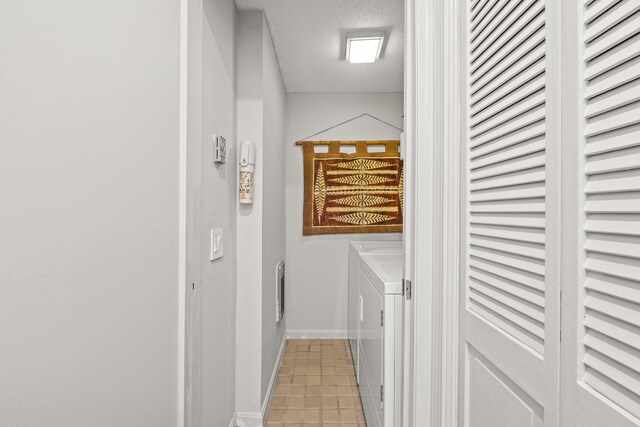 washroom featuring washer and clothes dryer and a textured ceiling